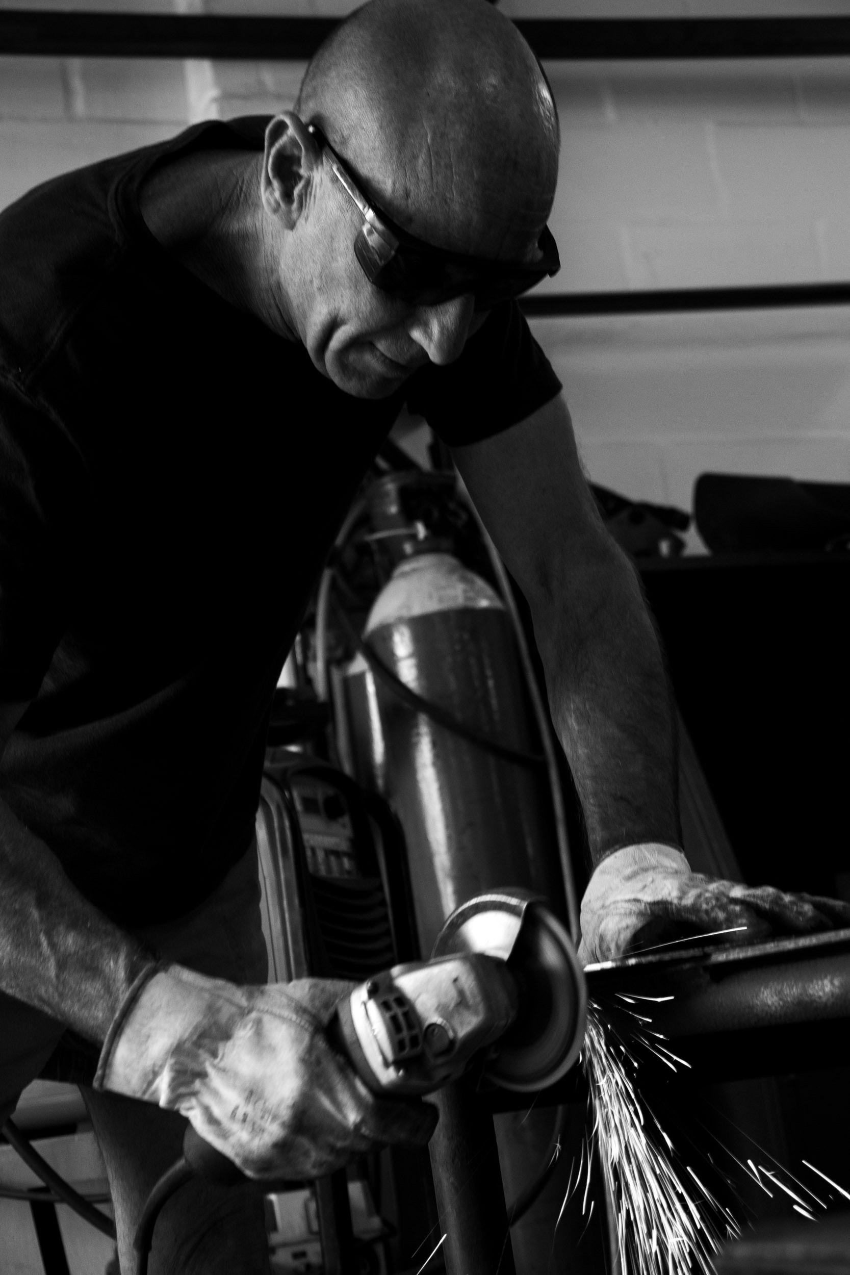 Black and white photo of a man cutting metal